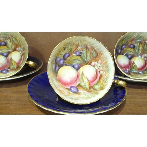 111 - Six each Aynsley cups and saucers decorated with fruit, signed D Jones on a blue ground.