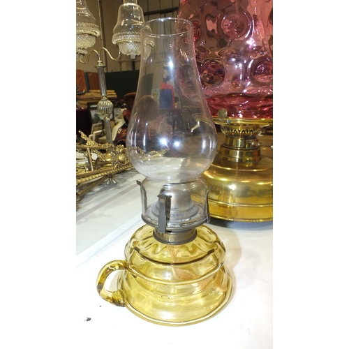 167 - A reproduction oil lamp with cranberry glass reservoir and brass column on ceramic plinth, a modern ... 