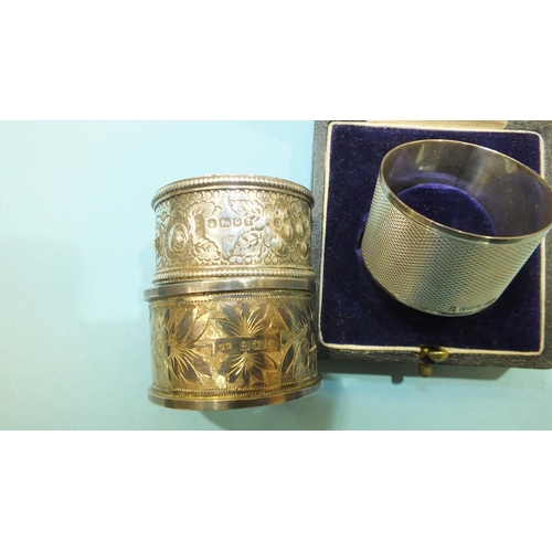 211 - An engine turned silver napkin ring,  Birmingham 1977 and two other silver napkin rings, (3).