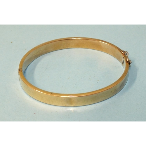 261 - A 9ct gold hinged bangle (small dent), 9.8g.