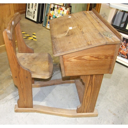 10 - An early 20th century pitch pine and elm school desk and chair, the desk with sloping hinged lid and... 
