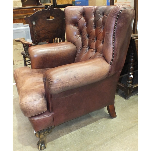 14 - A modern leather upholstered armchair on stained wood claw and ball feet, with button back, (soiled)... 