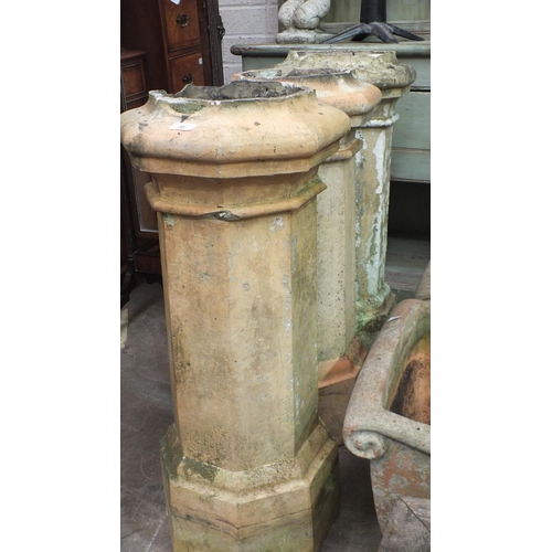 39 - Three chimney pots, 90cm high, (damages) and an octagonal reconstituted stone planter, 42cm high, 45... 