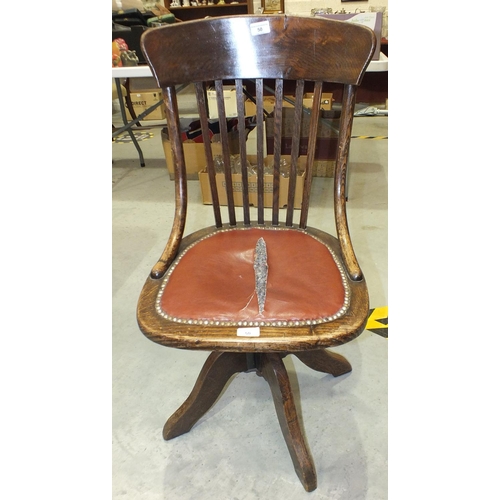 50 - A 1920's oak revolving office chair on quadruped base, (seat torn).