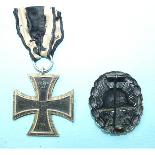 164 - A German WWI Iron Cross and a black wound badge, (2).