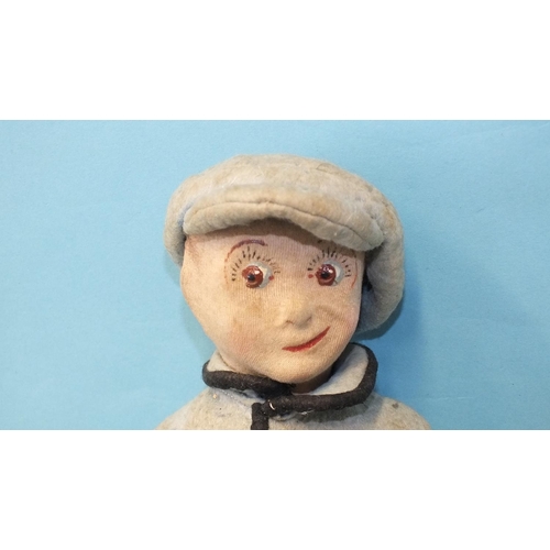 472 - A cloth boy doll, the stockinette-covered character face with cheeky expression, on jointed cloth bo... 