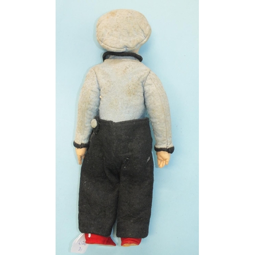 472 - A cloth boy doll, the stockinette-covered character face with cheeky expression, on jointed cloth bo... 