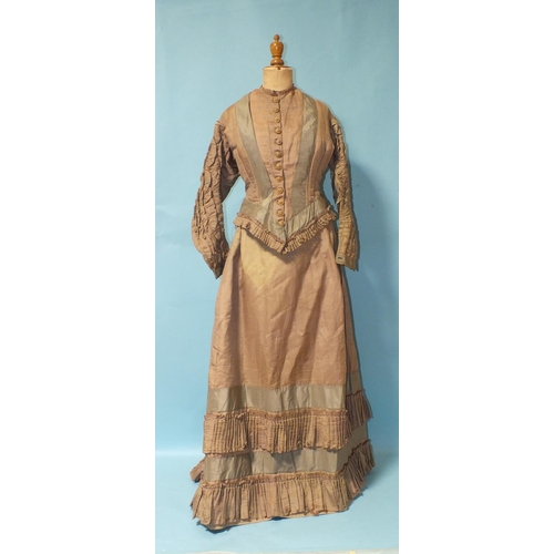 512 - A Victorian hand-stitched brown silk skirt, decorated with two flounces and taupe silk panels, a hea... 