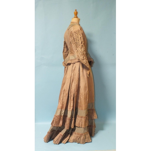 512 - A Victorian hand-stitched brown silk skirt, decorated with two flounces and taupe silk panels, a hea... 