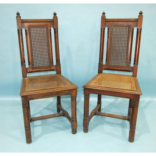 102 - A pair of Gothic-style oak hall chairs, each chamfered frame with caned back and seat (2).... 