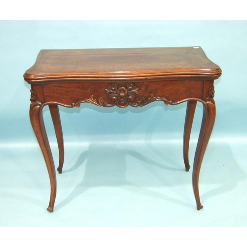 103 - A 19th century mahogany fold-over card table, the serpentine top with carved frieze and carved cabri... 