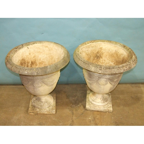 122 - A pair of cast concrete bell shape garden urns decorated with drapery, 61cm diameter, 68cm high.... 