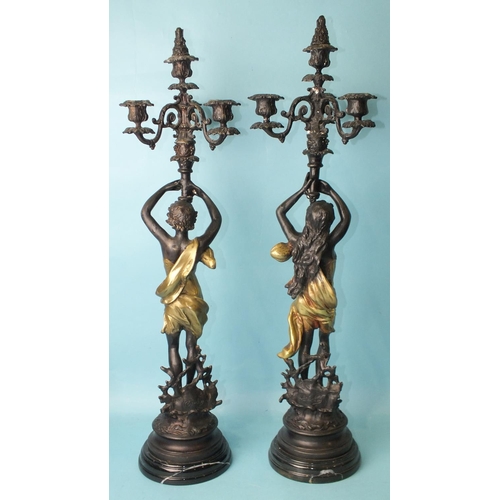 146 - After Emile Bruchon, a pair of reproduction bronzed metal figural candelabras, a male and a female f... 