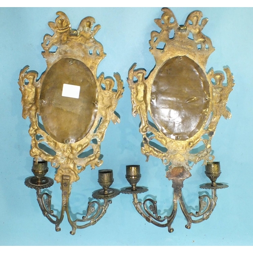 166 - A pair of cast brass and mirrored girandoles decorated with cherubs and ribbon-tied husks, 34cm high... 