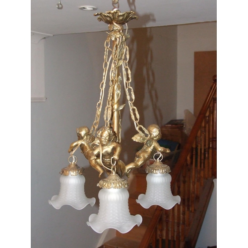 180 - A lacquered brass chandelier, the three branches modelled as winged cherubs from which are suspended... 