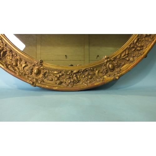 186 - A large Victorian gilt gesso circular wall mirror, the frame decorated with thistles and roses, arou... 