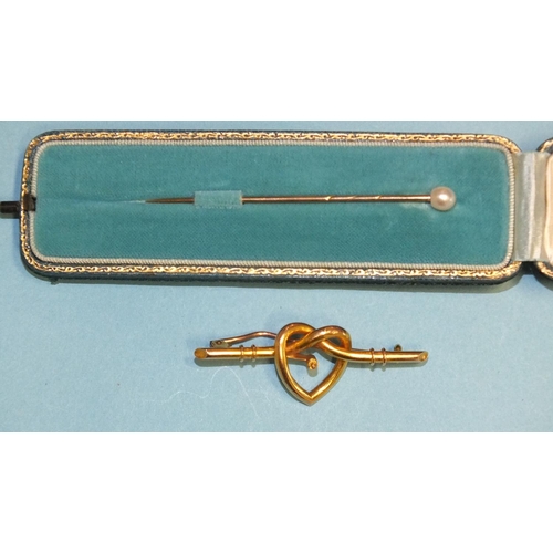 280 - A pearl-topped gold stick pin in fitted case and a lover's knot brooch with central screw fitting, (... 