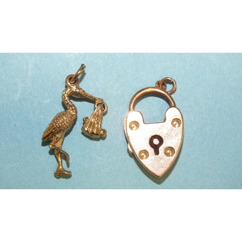 285 - A 9ct gold charm in the form of a stork carrying a baby and a 9ct gold padlock clasp, 4.6g, (2).... 