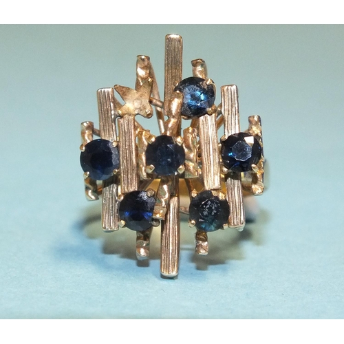 286 - An 18k gold dress ring of abstract form set six round-cut sapphires, (one setting vacant), size P, 4... 