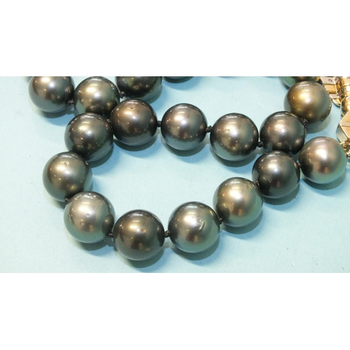 293 - A single-strand black pearl necklace composed of twenty-eight black cultured South Sea pearls, each ... 