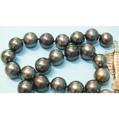 293 - A single-strand black pearl necklace composed of twenty-eight black cultured South Sea pearls, each ... 