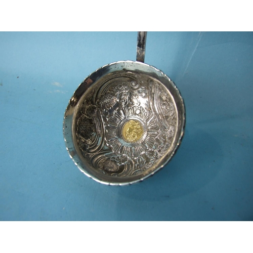 476 - A George III silver toddy ladle with embossed foliate and scroll decoration, inset a gold ¼-guinea c... 