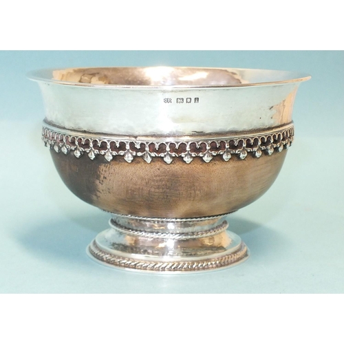 556 - Omar Ramsden, a silver-mounted mazer bowl, the circular wood body with hammered silver rim mount pie... 