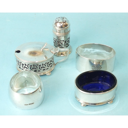 559 - A silver mustard and matching pepper with pierced scroll decoration, (glass liner to mustard a/f), B... 