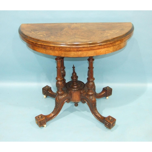 77 - A mid-Victorian walnut card table, the circular fold-over top inlaid with boxwood, raised on four ca... 