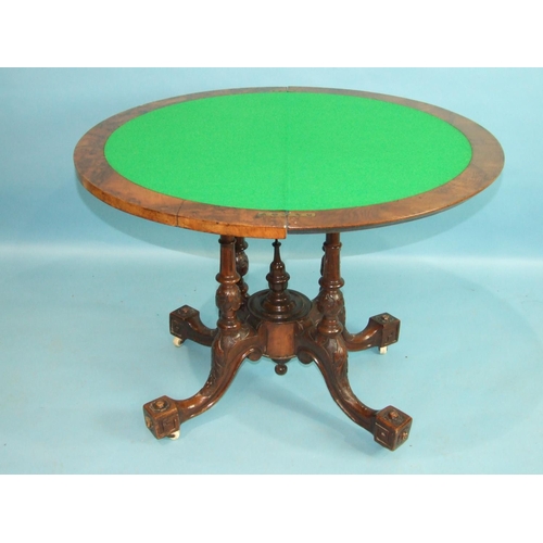 77 - A mid-Victorian walnut card table, the circular fold-over top inlaid with boxwood, raised on four ca... 