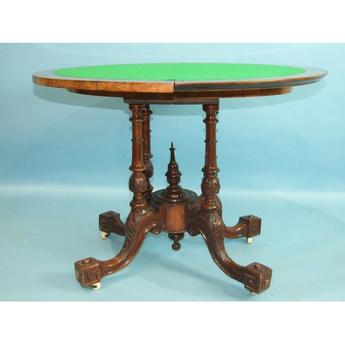 77 - A mid-Victorian walnut card table, the circular fold-over top inlaid with boxwood, raised on four ca... 