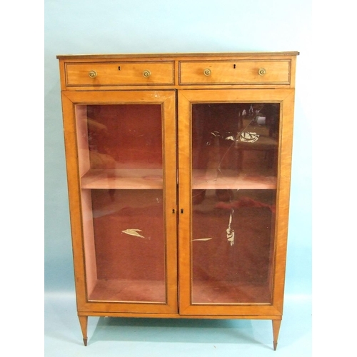 80 - A 19th century satinwood bookcase, having a pair of small drawers above two glazed doors, on square ... 