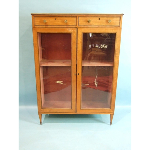 80 - A 19th century satinwood bookcase, having a pair of small drawers above two glazed doors, on square ... 