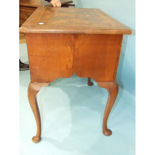 82 - An antique walnut lowboy, the cross-banded top above three drawers, on cabriole legs, 77cm wide and ... 