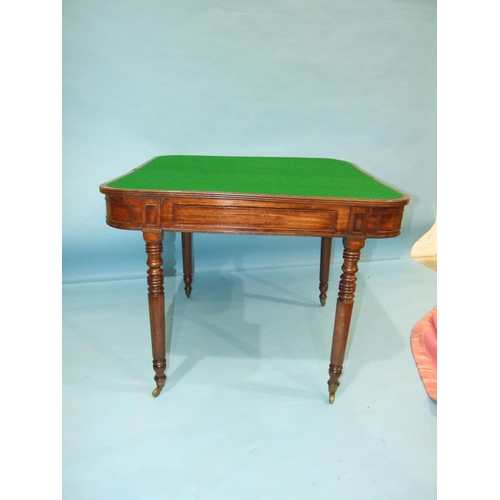 89 - A George IV mahogany fold-over card table, having a concealed frieze drawer on ring-turned legs with... 