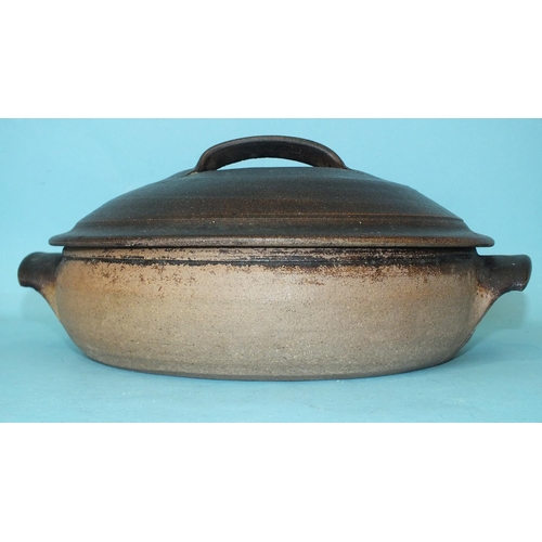 235 - Richard Batterham (b. 1936), a shallow casserole dish and cover in dark brown glaze, 32cm diameter.... 