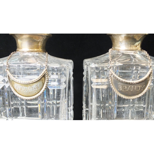 207 - A pair of square-form cut-glass decanters with silver mounts and silver wine labels, 'Brandy' and 'W... 