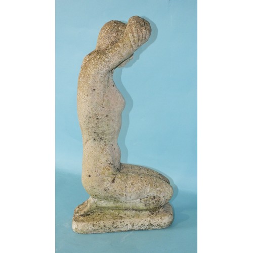 128 - A small cast concrete garden ornament in the form of a kneeling naked female figure with her arms fo... 