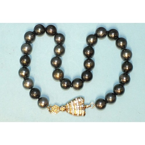 293 - A single-strand black pearl necklace composed of twenty-eight black cultured South Sea pearls, each ... 