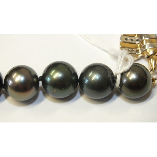 293 - A single-strand black pearl necklace composed of twenty-eight black cultured South Sea pearls, each ... 