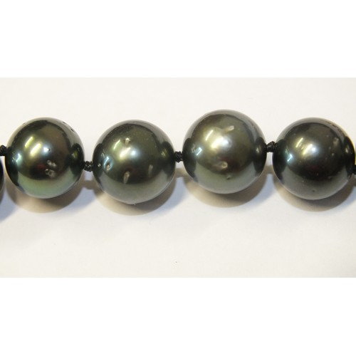 293 - A single-strand black pearl necklace composed of twenty-eight black cultured South Sea pearls, each ... 