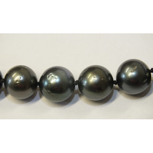 293 - A single-strand black pearl necklace composed of twenty-eight black cultured South Sea pearls, each ... 