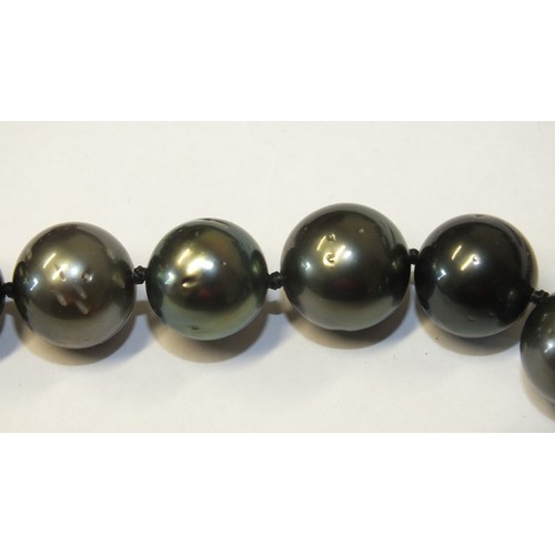 293 - A single-strand black pearl necklace composed of twenty-eight black cultured South Sea pearls, each ... 