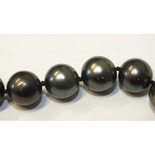 293 - A single-strand black pearl necklace composed of twenty-eight black cultured South Sea pearls, each ... 