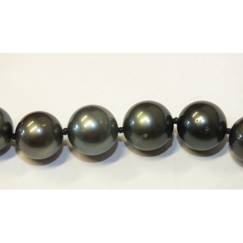 293 - A single-strand black pearl necklace composed of twenty-eight black cultured South Sea pearls, each ... 