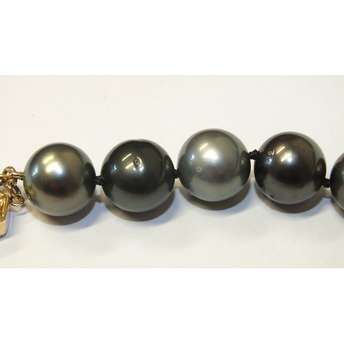 293 - A single-strand black pearl necklace composed of twenty-eight black cultured South Sea pearls, each ... 