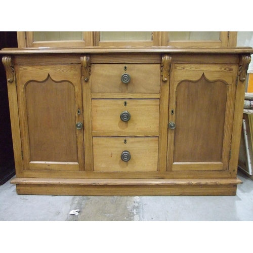 75 - A Victorian pitch pine dresser, the moulded cornice above three glazed doors, the lower part with th... 