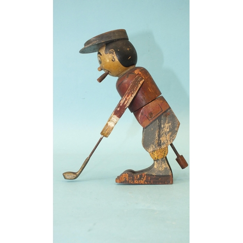 453 - A wooden toy in the form of a golfer teeing off, the figure twisting from the waist, constructed fro... 