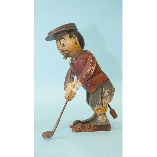 453 - A wooden toy in the form of a golfer teeing off, the figure twisting from the waist, constructed fro... 