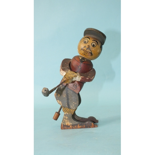 453 - A wooden toy in the form of a golfer teeing off, the figure twisting from the waist, constructed fro... 